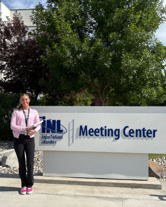 Lillian Beck poses with INL sign