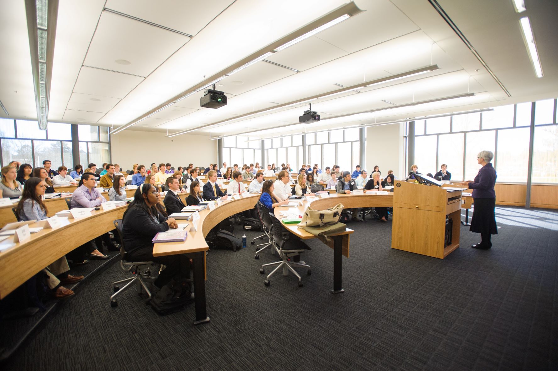 Large classroom listens to lecturer. 