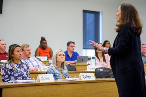 woman speaks in front of classroom