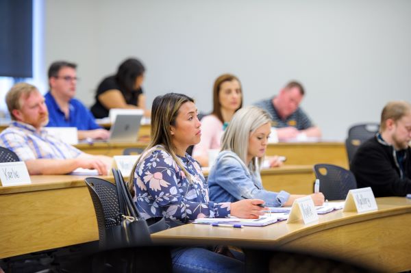 student in classroom listening to a speaker 