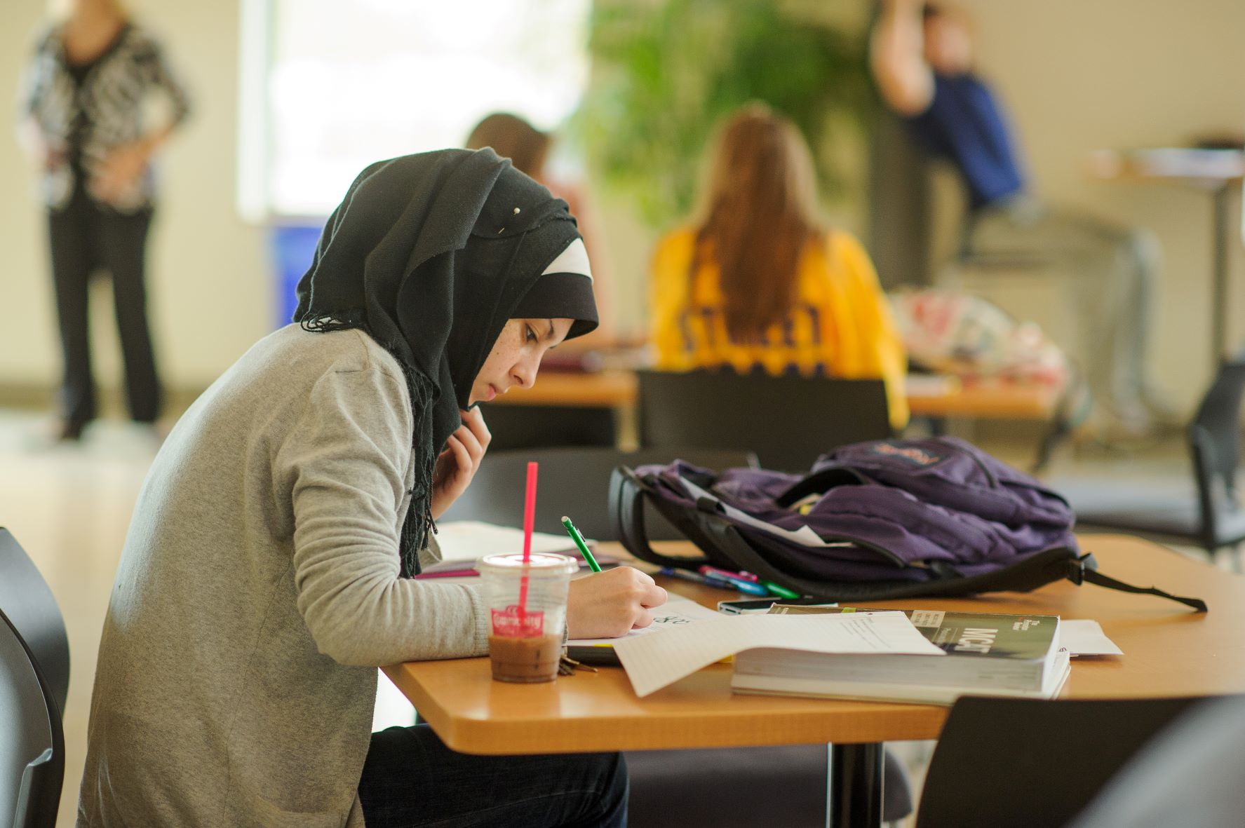 Female student writes a table in the BEC rotunda.