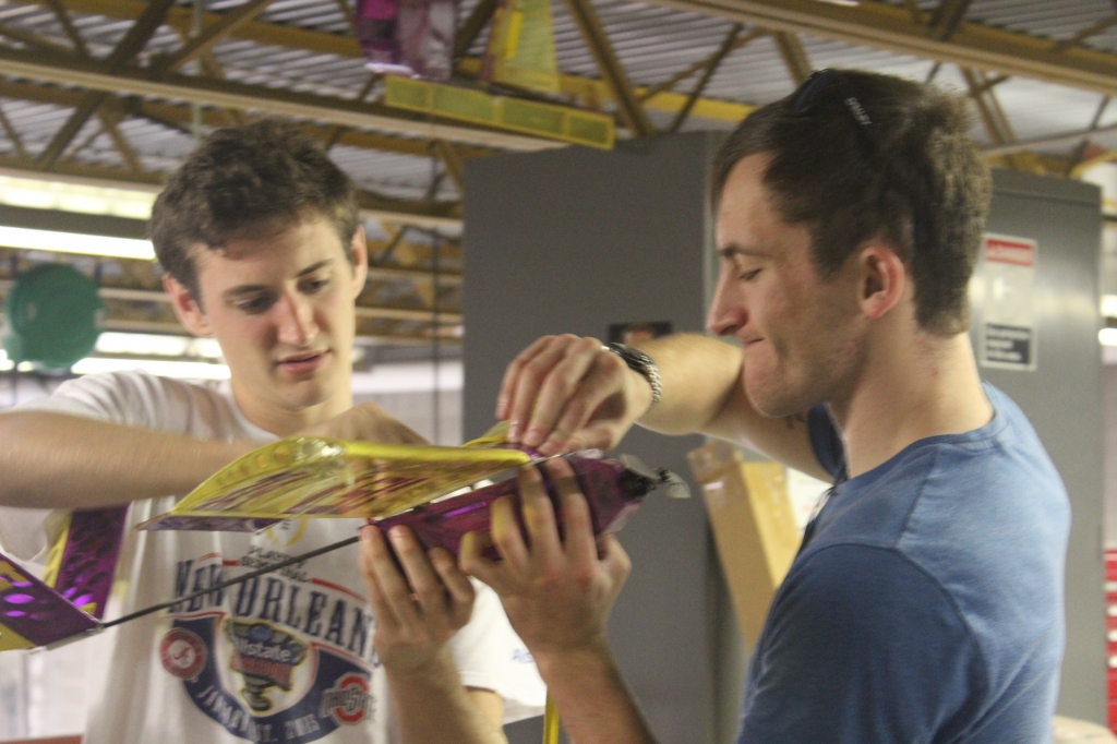 two students holding model plane