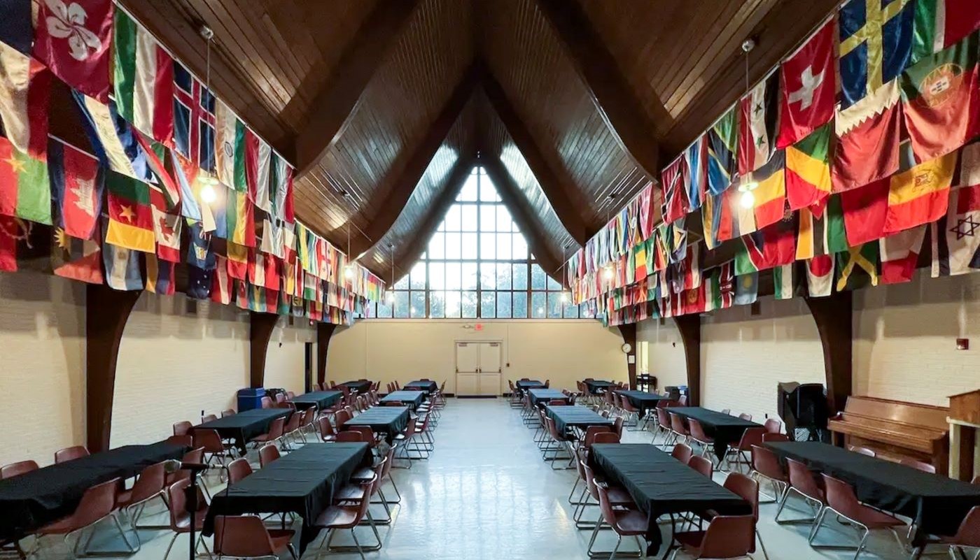 large event hall with flags of many nations hanging from the ceiling