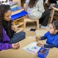 Student teacher works with child.