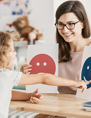 white woman showing signs of happy face and sad face to female child